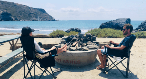 a man and women sitting in camping chairs at little harbors landmark double seal rock